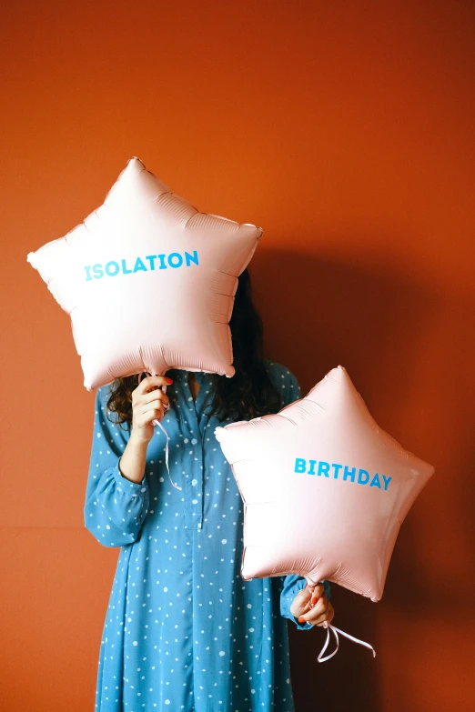 a woman holding two pillows in front of her face, a colorized photo, trending on unsplash, party balloons, ( ( risograph ) ), stellation, inflatable