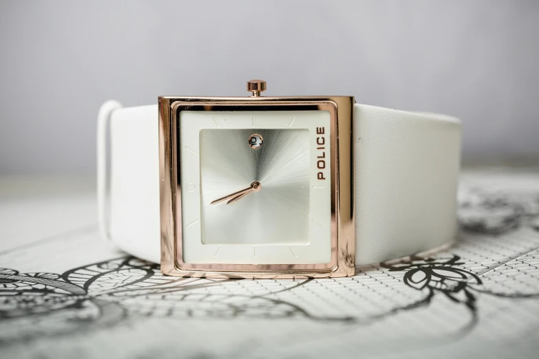 a close up of a watch on a table, an album cover, by Joe Bowler, trending on pexels, made of all white ceramic tiles, rose gold, with sparkling gems on top, square