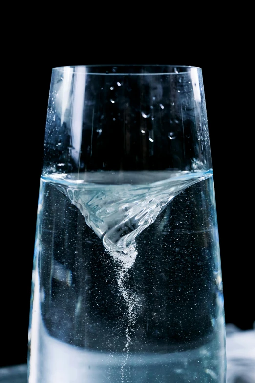 a glass of water sitting on top of a table, by Jan Rustem, unsplash, hyperrealism, detailed swirling water tornado, made of lab tissue, closeup of magic water gate, sharply shaped