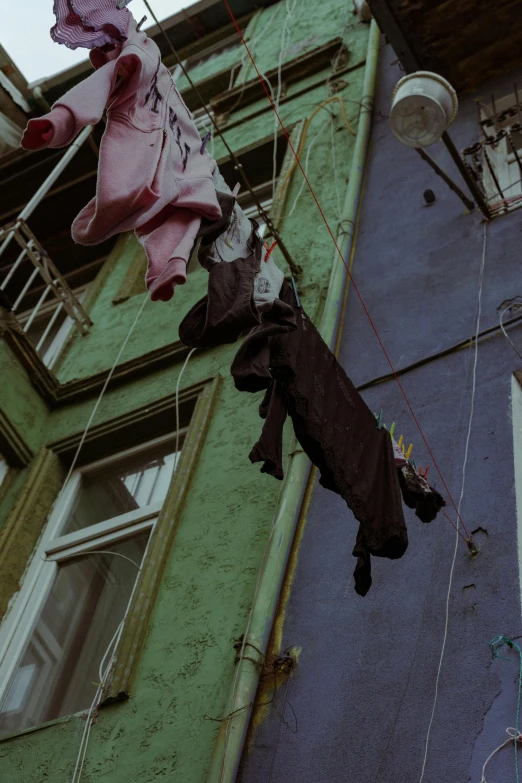 clothes hanging from a clothes line in front of a building, by Elsa Bleda, hyperrealism, istanbul, 90's color photo, darkwave goth aesthetic, multi - coloured