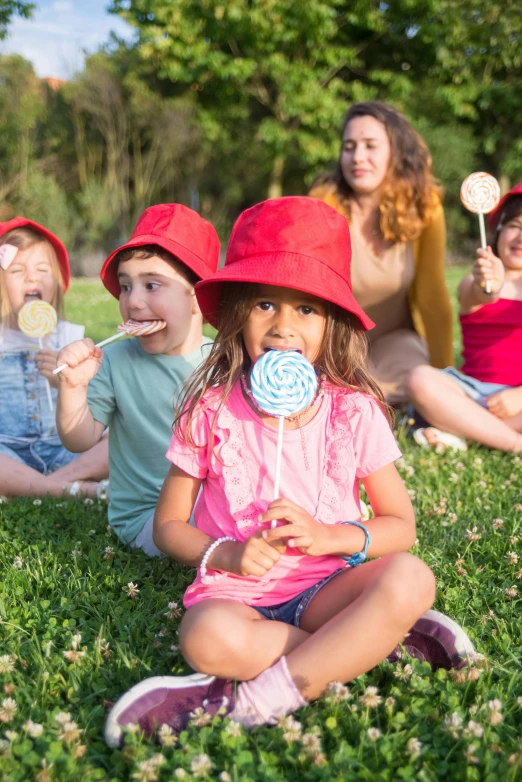 a group of children sitting in the grass with lollipops, wearing a cute hat, casual playrix games, in australia, adult