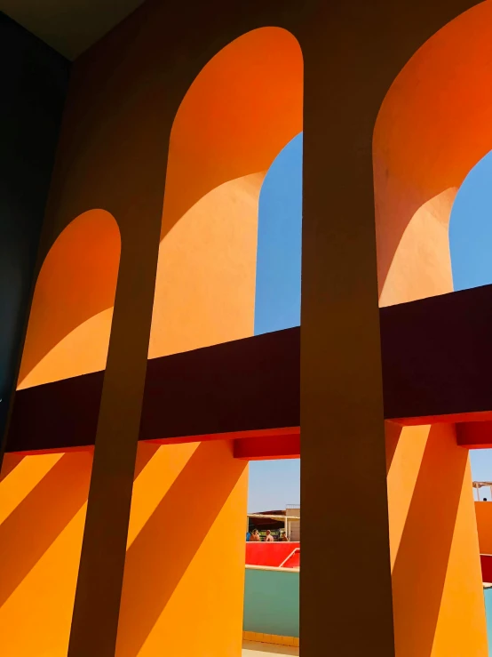 a view of a tennis court through a window, inspired by Ricardo Bofill, pexels contest winner, neo-fauvism, orange color, tall arches, color block, light and shadow