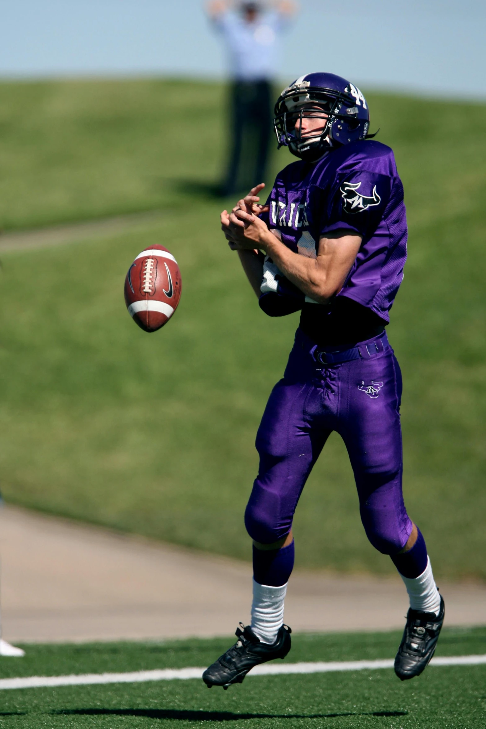 a man holding a football on top of a field, ((purple)), action sports photography, ap news photograph
