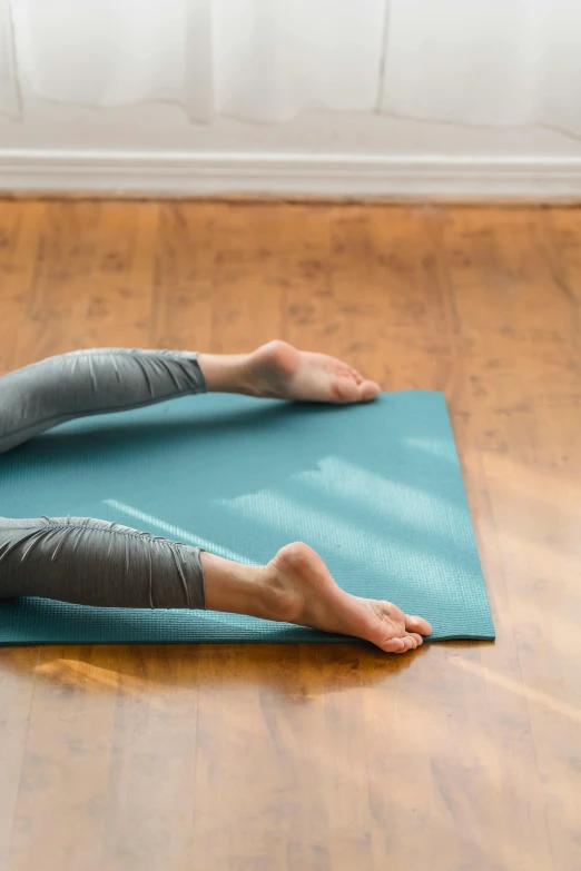 a woman laying on her stomach on a yoga mat, a picture, by Rachel Reckitt, shutterstock, arabesque, square, demur, no - text no - logo, standing