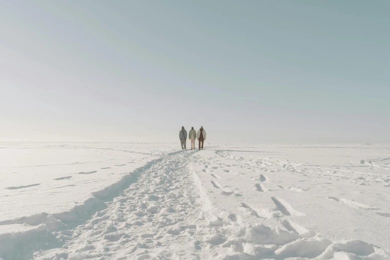 a group of people walking across a snow covered field, unsplash contest winner, minimalism, three women, hammershøi, bright sunny day, ignant