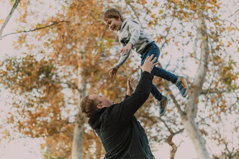 a man holding a young boy up in the air, pexels contest winner, avatar image, autumn season, super high resolution, game