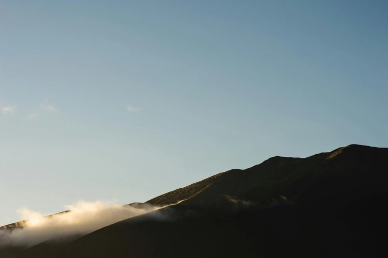 a person flying a kite on top of a mountain, by Peter Churcher, unsplash, hurufiyya, early morning light fog, new zeeland, slightly minimal, ignant