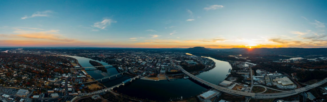 an aerial view of a city at sunset, by Andrew Domachowski, pexels contest winner, happening, looking over west virginia, wide angle river, 4 k cinematic panoramic view, alabama