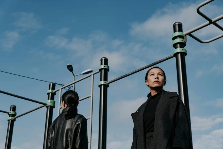 a couple of people standing next to each other, a portrait, unsplash, realism, playground, 2 techwear women, looking to the sky, lee madgwick & liam wong