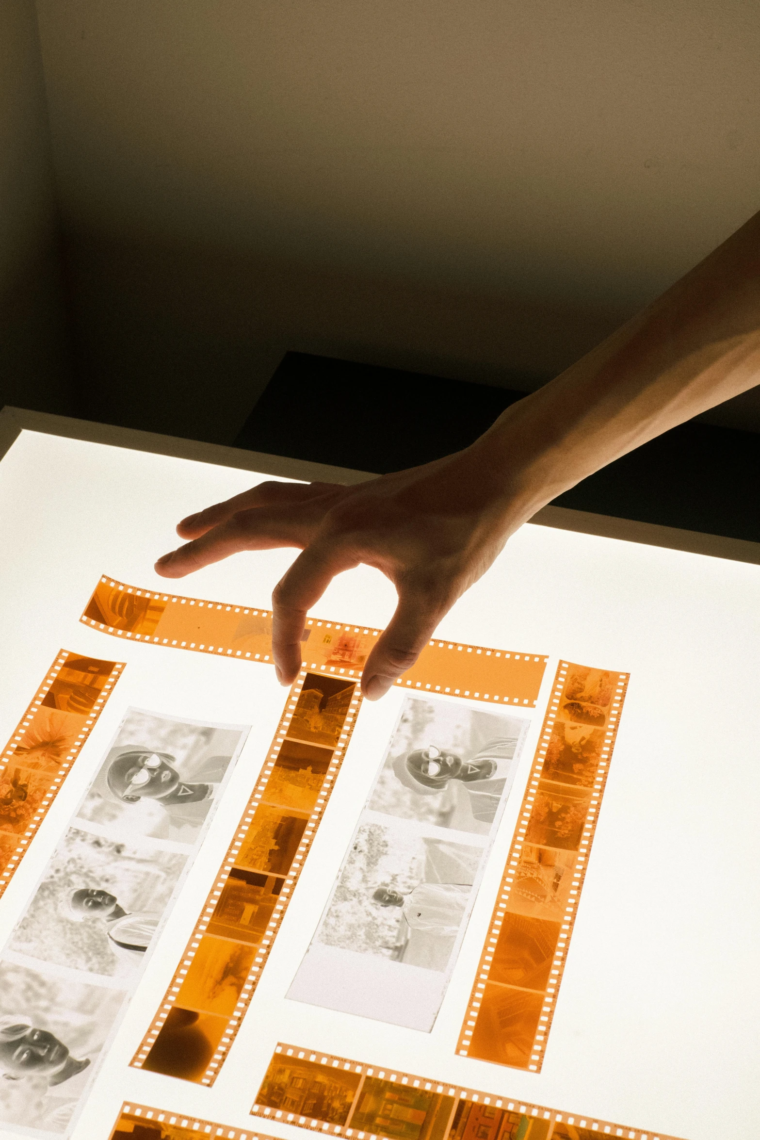 a person touching a piece of film on a table, beatifully lit, iconic design, historical, framing