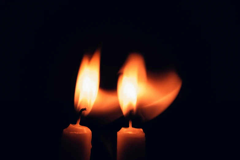 two lit candles in the dark, an album cover, inspired by Elsa Bleda, unsplash, flaming, getty images, ignant, mourning