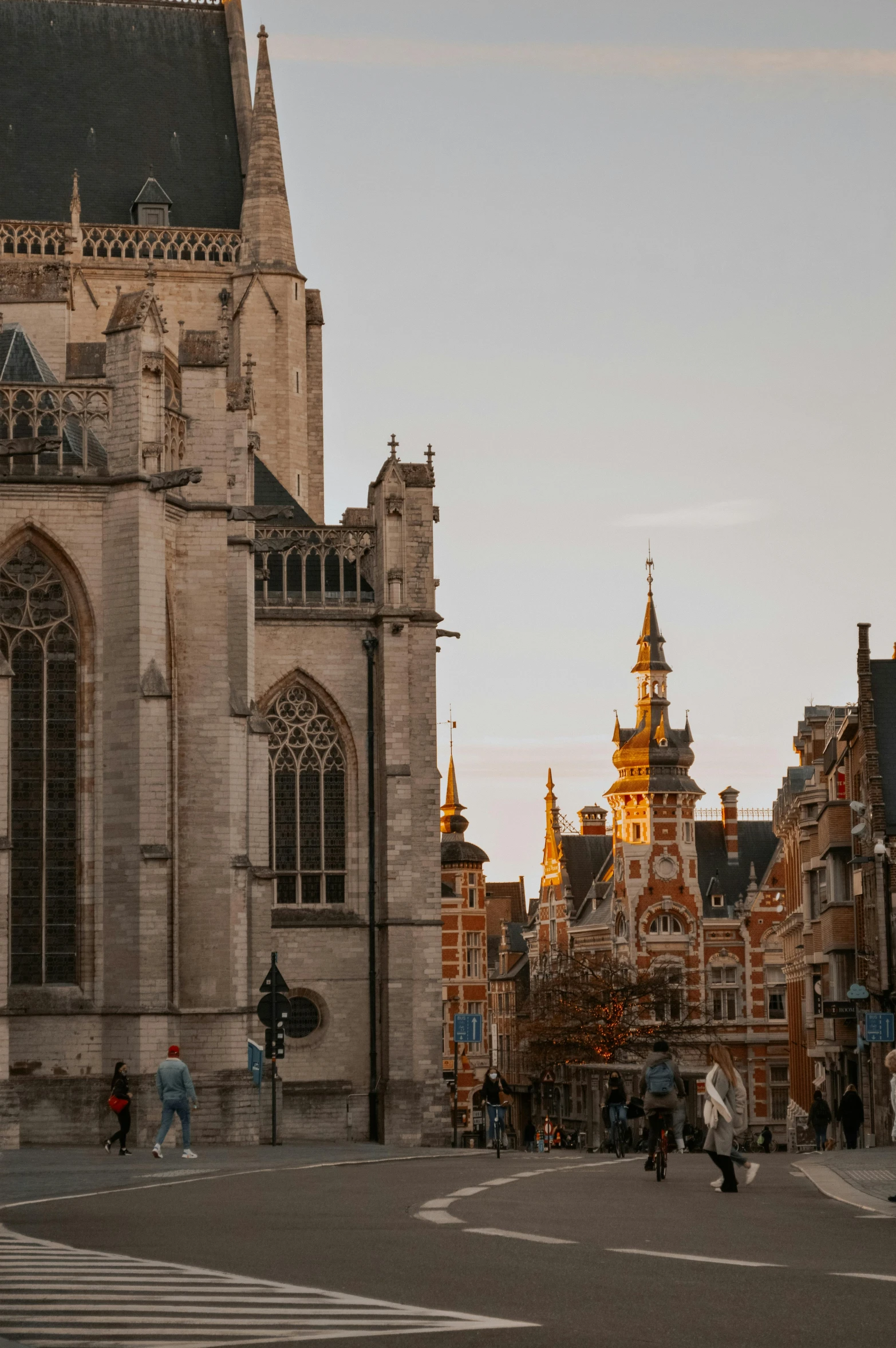 a group of people crossing a street in front of a church, by Daniel Seghers, pexels contest winner, baroque, golden hour hues, brutalist buildings, belgium, payne's grey and venetian red