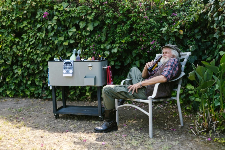 a man sitting in a chair next to a cooler, old gigachad with grey beard, lush surroundings, 3 / 4 wide shot, upcycled