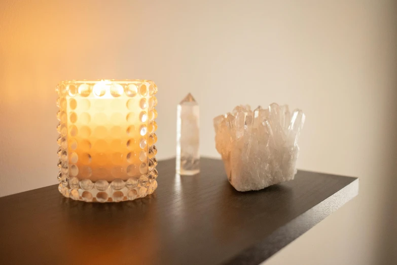 a candle that is sitting on a table, a marble sculpture, organic crystals, soft - lighting, knick knacks