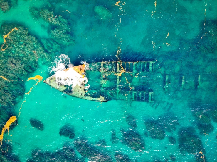 an aerial view of a boat in the water, by Gwen Barnard, pexels contest winner, sunken ship, wellington, destroyed, striking colour