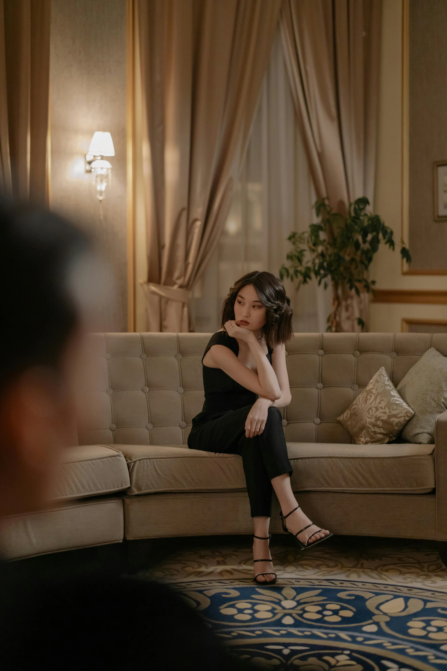 a woman sitting on a couch in a living room, pexels contest winner, realism, song hye - kyo, heartbroken, hotel room, raphael personnaz