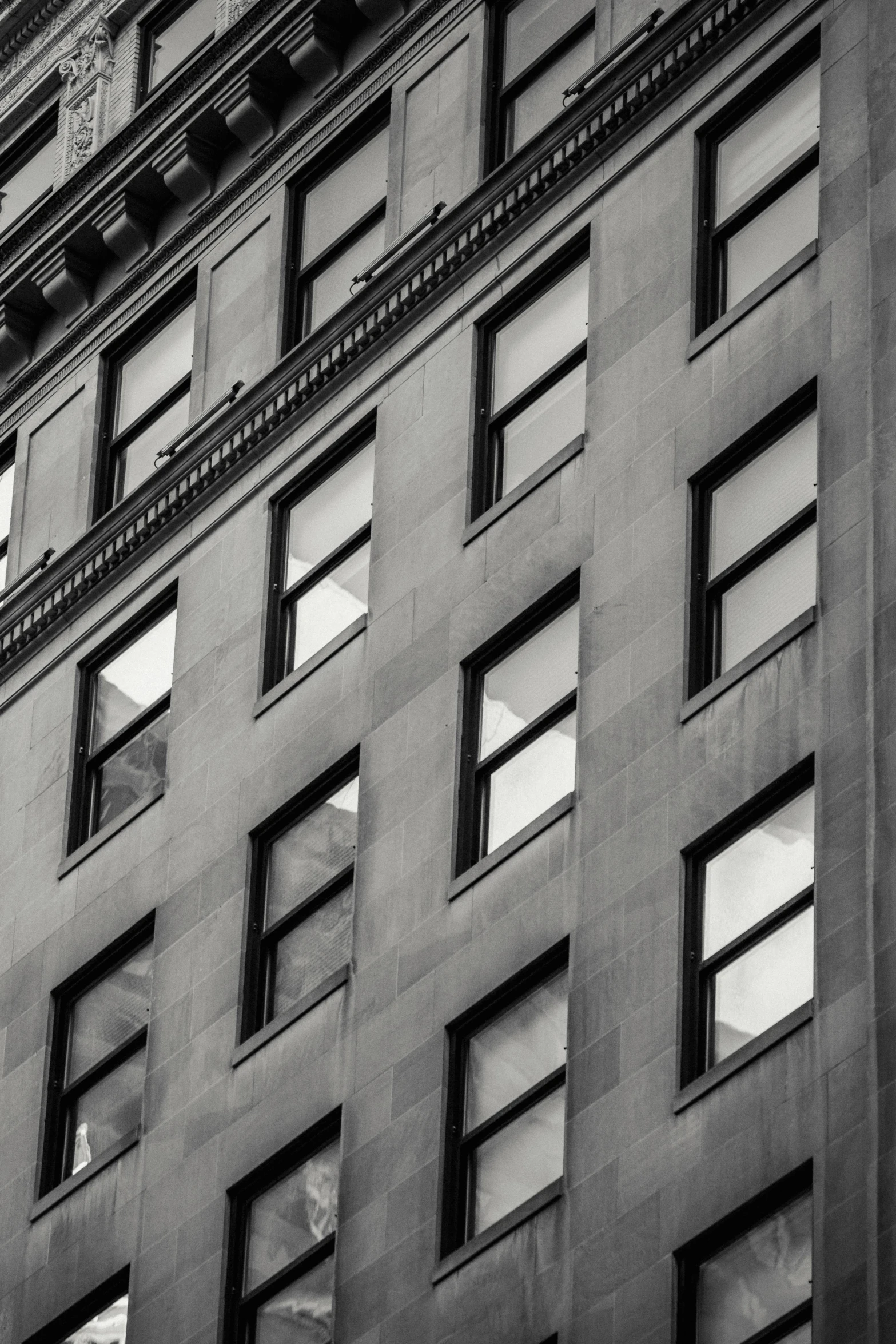 a black and white photo of a tall building, a black and white photo, inspired by Vivian Maier, pexels contest winner, square shapes, windows and walls :5, golden windows, buildings photorealism