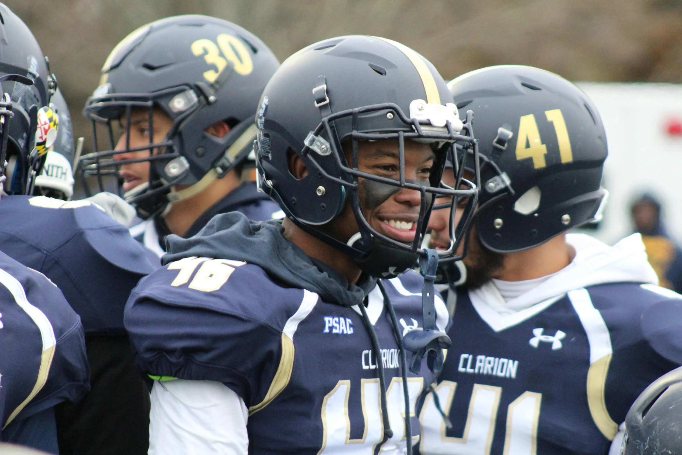 a group of football players standing next to each other, carrington, full helmet, smiles, photo from a spectator