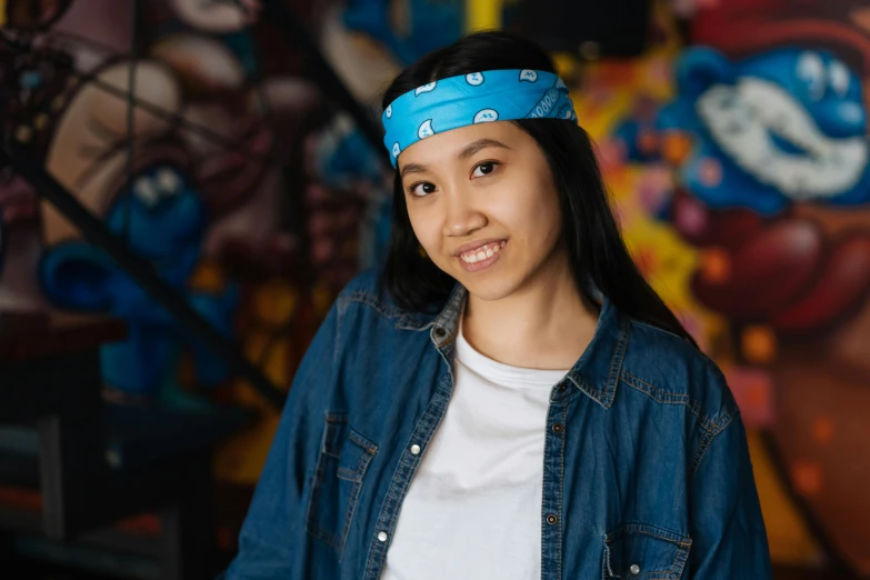 a woman standing in front of a graffiti wall, a character portrait, inspired by Mei Qing, pexels contest winner, teal headband, bandana, avatar image, student