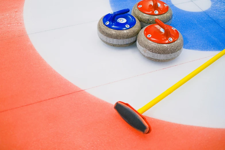 a group of curling stones sitting on top of a curling rink, a portrait, by Julia Pishtar, shutterstock contest winner, sweeping, 3 colour print, high angle close up shot, brown red blue