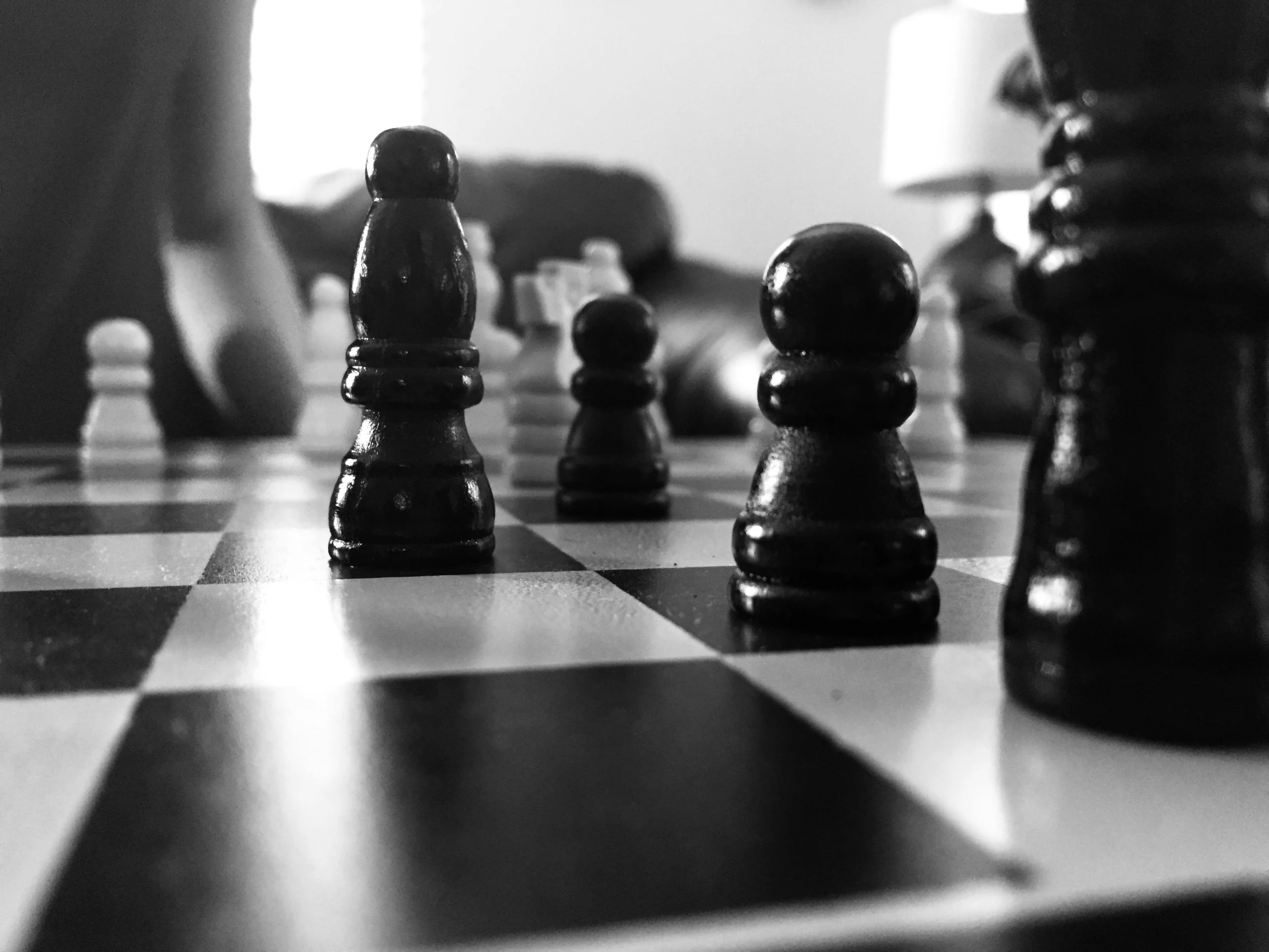 black and white chess pieces on a chess board, a black and white photo, by Adam Chmielowski, person in foreground, queen chess piece photo