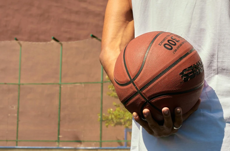 a close up of a person holding a basketball, in the sun, extra wide, exterior shot, instagram post