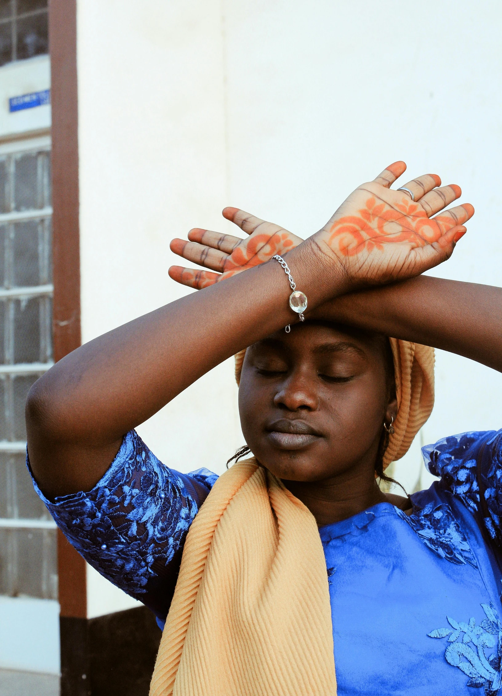 a woman with her hands on her head, by Ingrida Kadaka, trending on unsplash, somalia, hands shielding face, heat shimmering, in 2 0 1 5