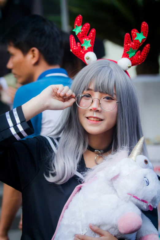 a woman with grey hair holding a stuffed unicorn, by Kanbun Master, reddit, music festival, indonesia, square, high-quality photo