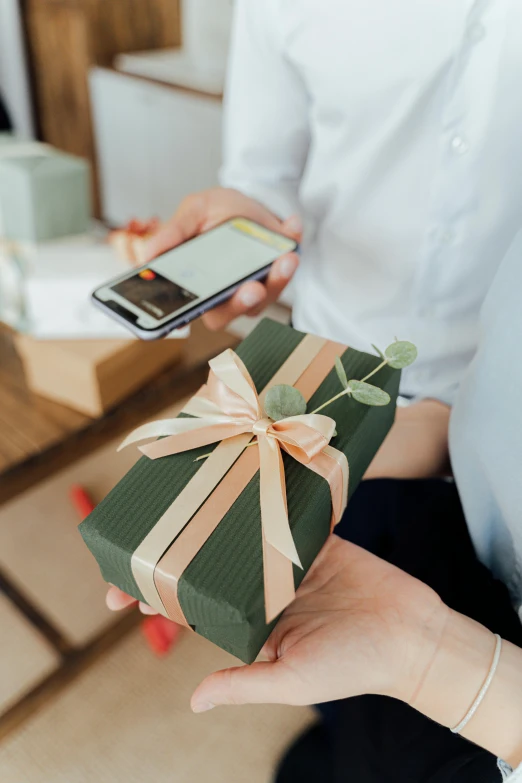 a close up of a person holding a present, phone, uploaded, vendors, sleek