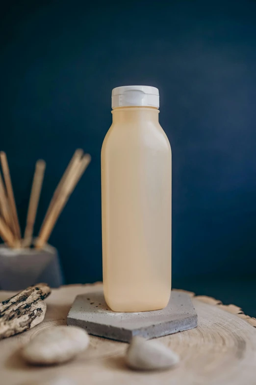 a bottle of liquid sitting on top of a table, soymilk, textured base ; product photos, dusk, utility