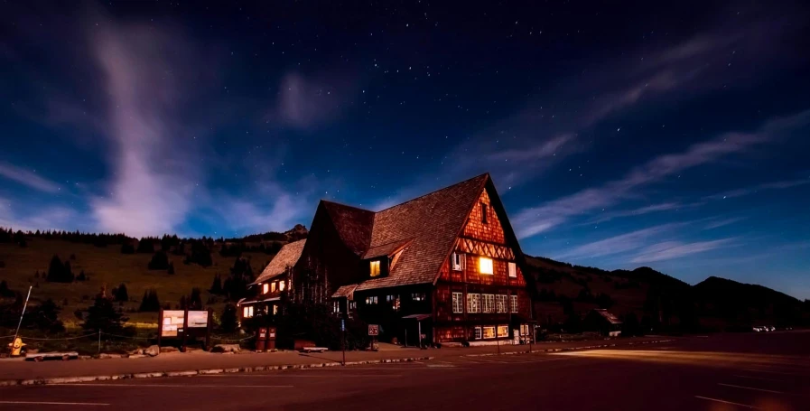 a large building sitting on the side of a road, by Sebastian Spreng, pexels contest winner, hobbiton at night, chalet, hollister ranch, profile image