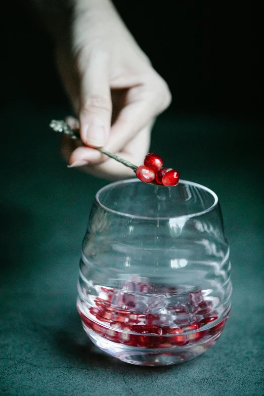 a person scooping cherries into a glass of water, inspired by André François, with red berries and icicles, handcrafted, crimson fork, silver red