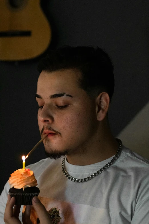 a man blowing out a candle on a cupcake, inspired by Eddie Mendoza, reddit, post malone, around 1 9 years old, bisexual lighting, huge chin