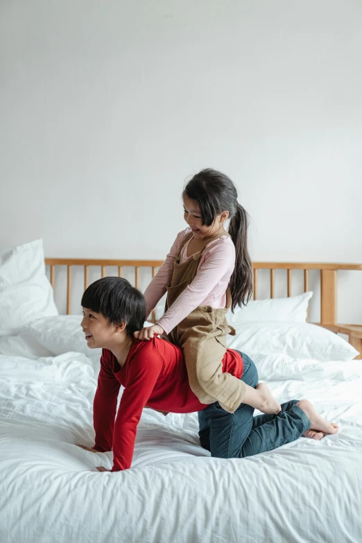 a couple of people that are on a bed, by Eizan Kikukawa, pexels contest winner, kids playing, bendover posture, shirt, tithi luadthong