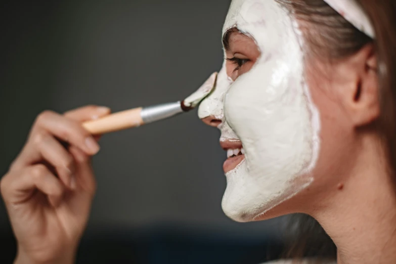 a woman putting a facial mask on her face, profile image, fan favorite, commercial photo, silver