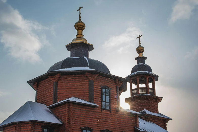a large red brick building with two spires, inspired by Andrei Rublev, pexels contest winner, cloisonnism, peaked wooden roofs, winter photograph, orthodox christianity, first light