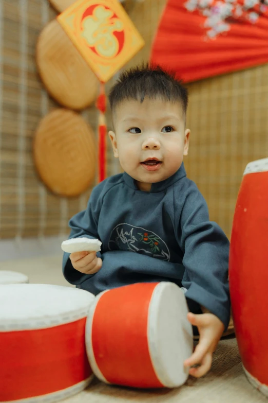 a little boy that is sitting on the floor, an album cover, inspired by Gong Xian, pexels contest winner, happening, steamed buns, drummer, 15081959 21121991 01012000 4k, medium detail