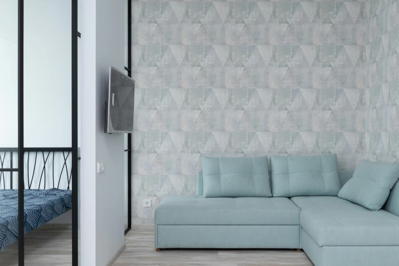 a blue couch sitting in a living room next to a bed, inspired by Constantin Hansen, trending on cg society, photo - realistic wallpaper, pastel faded effect, flat triangles, silver and muted colors