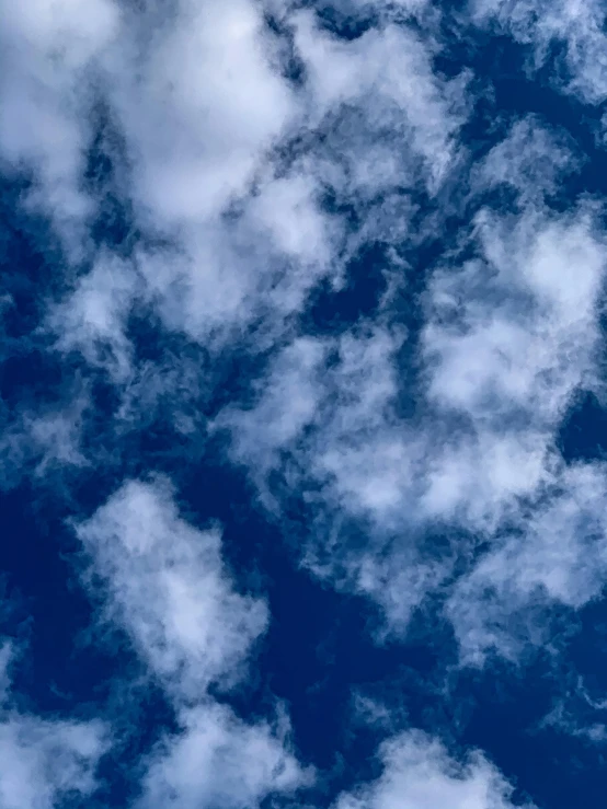 a plane flying through a cloudy blue sky, an album cover, trending on unsplash, renaissance, ☁🌪🌙👩🏾, cloud nebula, accidentally photographed, background image