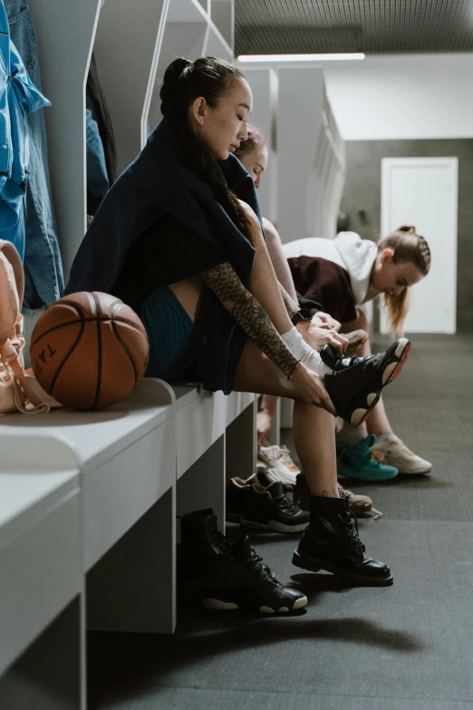 a group of people sitting next to each other in a locker, trending on pexels, basketball court, on knees, at checkout, female