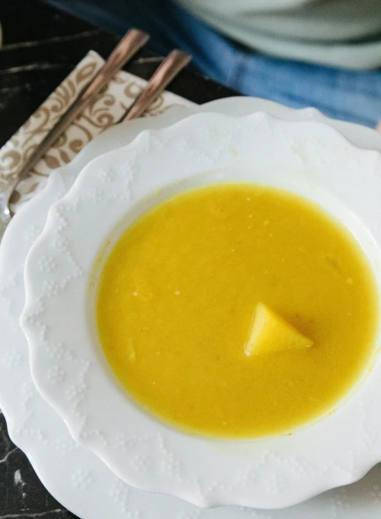 a bowl of soup sitting on top of a white plate, mango, square, thumbnail, harvest