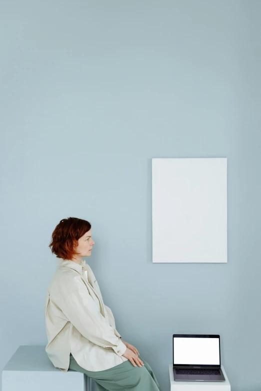 a woman sitting in front of a laptop computer, a minimalist painting, inspired by Agnes Martin, trending on unsplash, postminimalism, white and pale blue, standing in corner of room, woman with red hair, 144x144 canvas