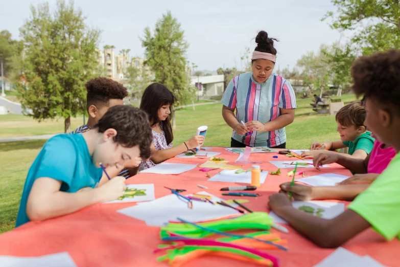 a group of children sitting around a table, process art, at a park, cal-arts, millennial vibes, gourmet and crafts