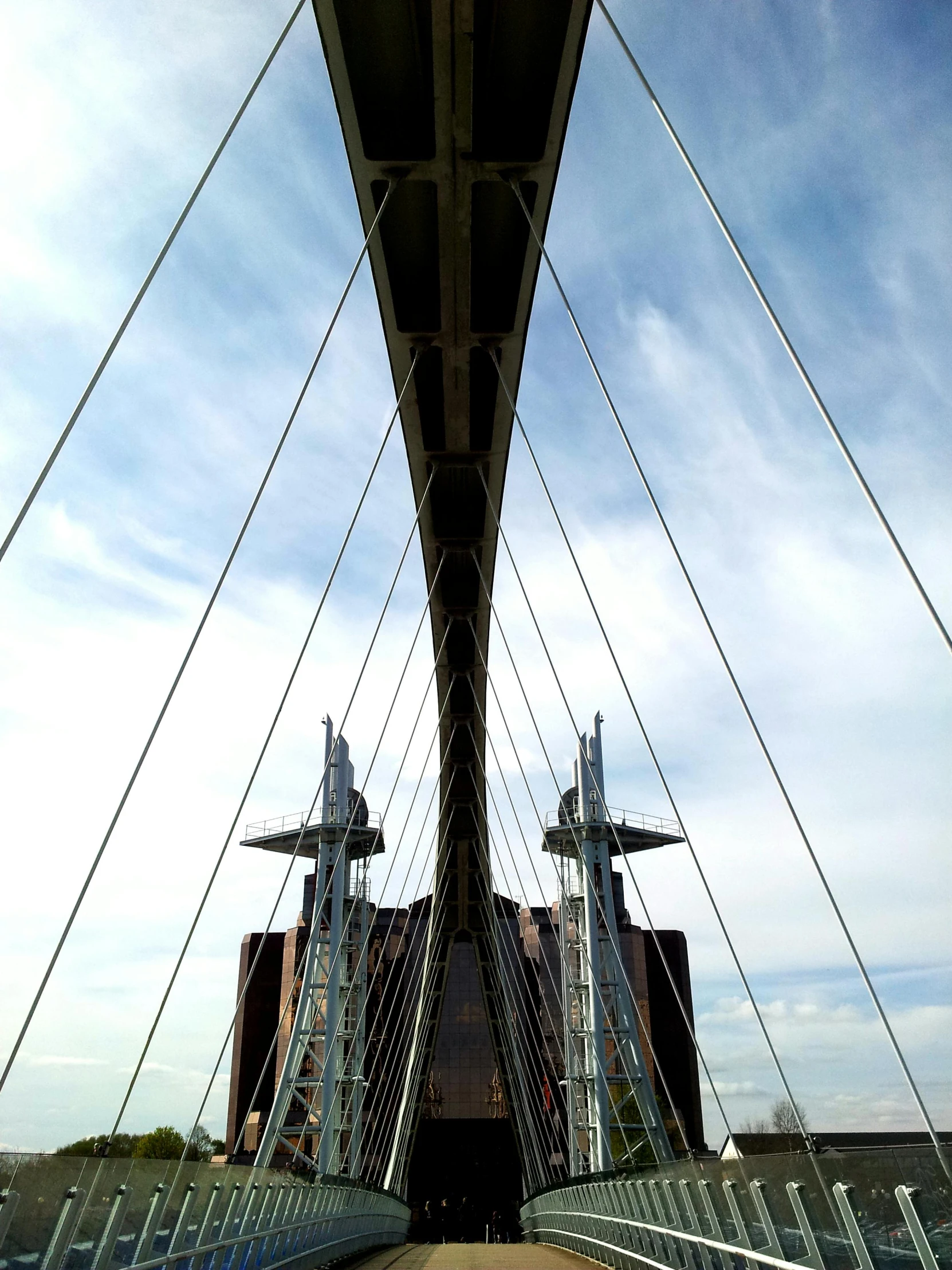 a bridge over a body of water under a blue sky, an album cover, inspired by Wifredo Lam, unsplash, modernism, cables hanging, huge support buttresses, closeup - view, taken on iphone 14 pro