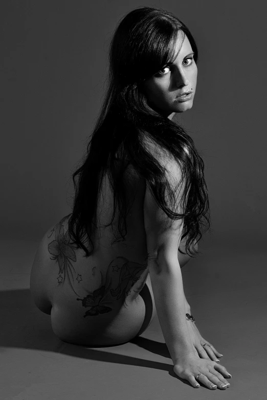 a black and white photo of a woman with tattoos, by Clifford Ross, megan fox witch queen, bum, side