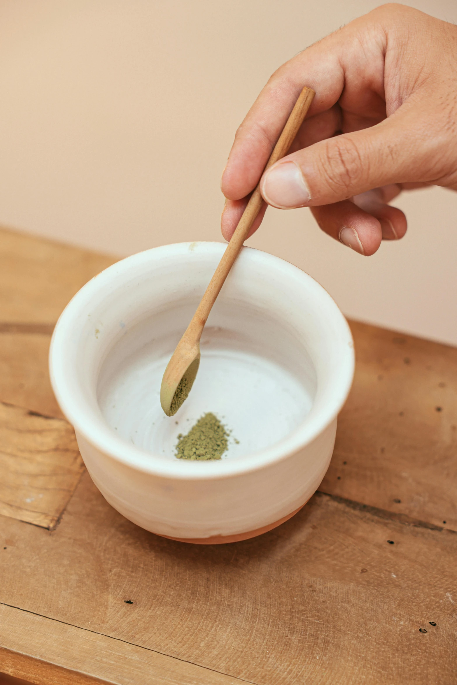 a person stirring something in a bowl with a wooden spoon, inspired by Kanō Shōsenin, green facemask, detailed product image, magic powder, small in size