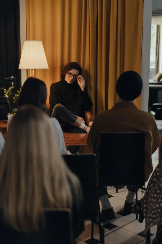 a group of people sitting around a table in a room, ville valo, business meeting, photo of a woman, alessio albi