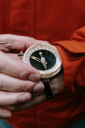 a close up of a person holding a watch, by Jan Tengnagel, explorers, cartographic, documentary still, vintage pilot clothing