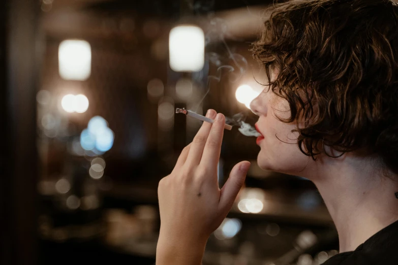 a woman smoking a cigarette in a bar, inspired by Nan Goldin, trending on pexels, hyperrealism, finn wolfhard, harry potter smoking weed, profile image, with shiny skin