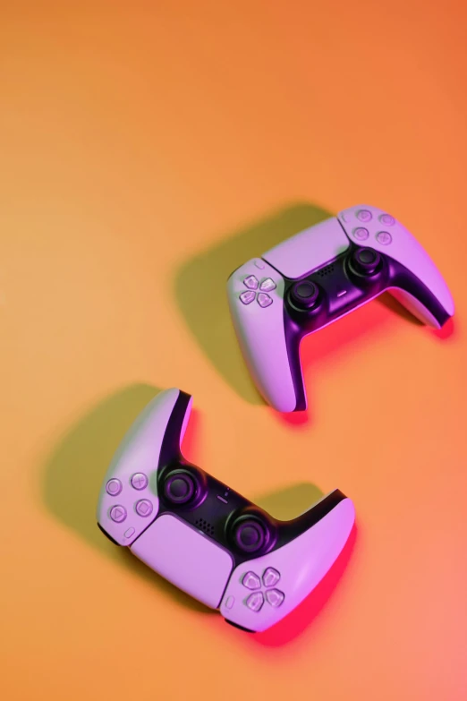two video game controllers sitting next to each other, a digital rendering, pexels, purple orange colors, instagram post, yellow infrared, cover shot
